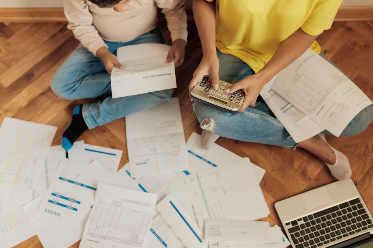 shows two people sorting piles of paperwork related to their debt and finances