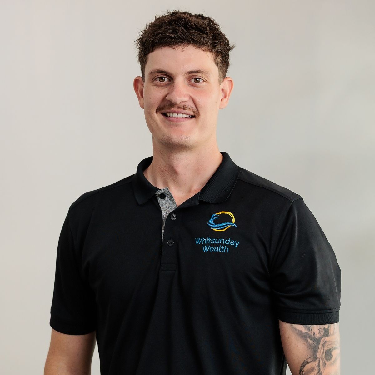 Professional headshot of Ben Oliver-Arnold with plant in background