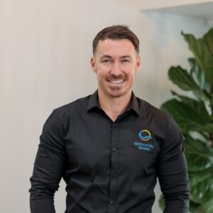 Professional headshot of Matthew Niell with plant in background